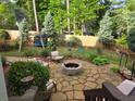 Enjoy the backyard complete with stone patio, fire pit, lush greenery, swing set, and fenced yard at 811 Millvale Pl, Lawrenceville, GA 30044