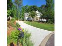 A long driveway leads to a charming home surrounded by lush greenery and beautiful landscaping at 811 Millvale Pl, Lawrenceville, GA 30044