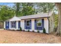 A charming home with blue shutters, freshly painted white brick, and newly installed landscaping at 6932 Eunice Dr, Riverdale, GA 30274