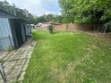 Large, grassy backyard featuring a small tree and a mix of wooden and chain-link fencing at 3730 Clovis Nw Ct, Atlanta, GA 30331