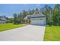 Light blue one-story home with a two-car garage and a long concrete driveway on a sunny day at 85 Presley Farm Pkwy, Rockmart, GA 30153