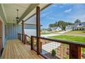 Cozy covered front porch featuring wood flooring, rustic railing, and stylish pendant lighting at 85 Presley Farm Pkwy, Rockmart, GA 30153