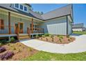 Inviting one-story home with light blue siding, a covered porch, and professionally landscaped front yard at 85 Presley Farm Pkwy, Rockmart, GA 30153