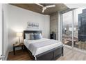 Cozy bedroom with large windows, city views, and hardwood floors at 855 Peachtree Ne St # 1508, Atlanta, GA 30308