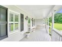 Covered porch featuring a swing, white railings, and views of the front yard at 2759 Bay Ridge Dr, Loganville, GA 30052