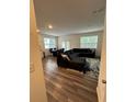 Bright open living area with wood floors, featuring a comfortable sectional sofa and dining space at 3558 Eagle Court, Fulton, GA 30331