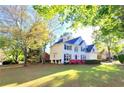 Beautiful home with a well-manicured lawn, blue shutters, and flowering shrubs at 505 Tilbury Dr, Suwanee, GA 30024