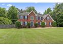 Attractive two-story brick home featuring a lush green lawn and tidy landscaping in a suburban setting at 129 Crown Walk, Mcdonough, GA 30253