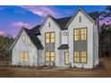Beautiful modern two-story home with light brick, dark trim, and manicured landscaping at dusk at 3735 Tamiami Trl, Cumming, GA 30041