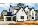 Angle shot of a modern two-story home with light brick, dark trim, garage, and manicured landscaping at 3735 Tamiami Trl, Cumming, GA 30041