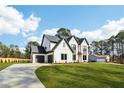 Expansive view of a modern home with a long driveway, complemented by a lush green lawn and mature trees at 3735 Tamiami Trl, Cumming, GA 30041