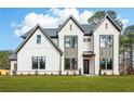 Stunning exterior of a two-story home featuring white brick and modern black-trimmed windows on a lush lawn at 3735 Tamiami Trl, Cumming, GA 30041
