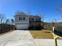 Stately two-story home featuring a two-car garage, long concrete driveway, and a well-kept lawn at 5342 Legacy Trl, Douglasville, GA 30135