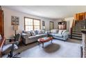 Bright living room with neutral walls, plush grey carpeting, and comfortable sofas flanking a staircase at 1102 Waverly Dr, Lawrenceville, GA 30046