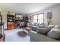 Comfortable living room featuring plush grey sofas, carpeted floors, and classic wooden cabinets at 1102 Waverly Dr, Lawrenceville, GA 30046