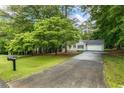 A tranquil view of the home with a long driveway and a mailbox in a lush, wooded setting at 1154 Pinebrook Rd, Auburn, GA 30011