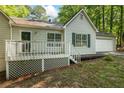 This charming home features a well-maintained exterior with a front deck and lush landscaping at 1154 Pinebrook Rd, Auburn, GA 30011