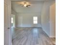 Bright open-concept living room features soaring ceilings, modern gray vinyl floors, and natural light at 28 Loth Wages (Lot 28) Rd, Dacula, GA 30019