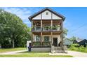 Charming two-story home showcasing a double-decker front porch with lush plants on both balconies at 1228 Ladd Sw St, Atlanta, GA 30310