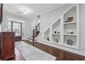 Elegant foyer with hardwood floors, staircase, and custom built-in shelving, creating a warm and inviting entrance at 1974 Hosack Sw Hl, Marietta, GA 30064