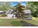 Cozy home showcasing a lush front lawn, mature landscaping, and a two-car garage at 231 Clarion Rd, Lawrenceville, GA 30043