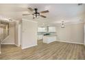 Spacious living room with wood-look floors that flows into a kitchen with white cabinets and granite countertops at 50 Fieldview Ln, Covington, GA 30016