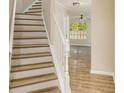 Open staircase showcasing wood-look steps and white railings leading to the main living area at 50 Fieldview Ln, Covington, GA 30016