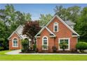Charming red brick home featuring an immaculate lawn, arched windows, and professional landscaping at 7406 Cherry Blossom Way, Winston, GA 30187