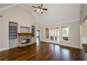 Bright living room with hardwood floors, a fireplace, built-in bookshelves, and vaulted ceilings at 9157 Golfview Cir, Covington, GA 30014