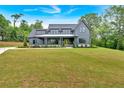 Gray modern farmhouse with covered porch and professionally landscaped yard at 157 Palisade Ne Dr, Rydal, GA 30171