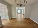 An open dining room featuring luxury vinyl plank flooring and a modern chandelier at 5464 Fox Haven Trl, Stone Mountain, GA 30088