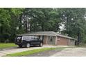 Inviting one-story home with manicured lawn and a parked SUV in the driveway at 679 Winchester Ln, Norcross, GA 30071