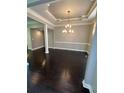 Open dining area featuring dark wood floors and modern chandelier at 1305 Lake Forest Ln, Mcdonough, GA 30253