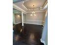 Dining room with coffered ceilings, hardwood floors, and modern chandelier at 1305 Lake Forest Ln, Mcdonough, GA 30253