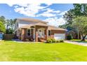 Beautiful home exterior with brick accents, lush green lawn, and mature trees at 1480 Shady Cove Ln, Lawrenceville, GA 30043