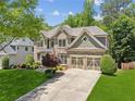 Beautiful two-story home with brick accents, a two-car garage, and a lush green lawn at 1320 Magnolia Park Cir, Cumming, GA 30040
