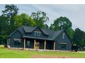 Beautiful two-story home boasts a black exterior, spacious yard and wooded backdrop at 1111 Lake Varner Dr, Covington, GA 30014