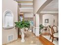 Elegant foyer with a grand staircase, arched doorways, and beautiful tile and hardwood floors at 127 Courts Of Hampton, Hampton, GA 30228