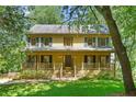 Classic two-story home with a large front porch, blue shutters, and lush green lawn at 2120 Habersham Trce, Cumming, GA 30041