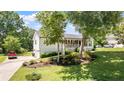 Well-maintained home exterior featuring a classic white facade, inviting porch, and a beautifully landscaped front yard at 2675 Springside Ct, Douglasville, GA 30135