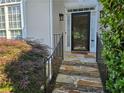 Inviting front entrance with stone steps, decorative railing, and lush landscaping at 3773 Summer Rose Dr, Atlanta, GA 30341