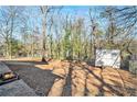 Spacious backyard with mature trees, a fire pit, and a storage shed at 1040 Forest East Dr, Stone Mountain, GA 30088