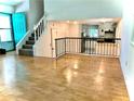 Open floor plan showcasing hardwood floors with kitchen view and a staircase leading to the upper level at 1040 Forest East Dr, Stone Mountain, GA 30088