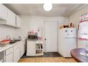Compact kitchen featuring dated white cabinets, appliances, and vinyl flooring at 2293 Ewing Sw St, Atlanta, GA 30331