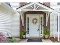Close up of front door with decorative wreath, red brick accent, and matching planters at 2101 Emerald Dr, Loganville, GA 30052