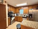 Cozy kitchen with stainless steel appliances, granite countertops, and oak cabinetry at 2523 Bronco Trl, Duluth, GA 30096
