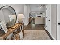 Stylish entryway featuring wood floors, a decorative mirror, and an open view to the living area at 620 Alcovy Springs Dr, Lawrenceville, GA 30045