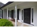 Inviting covered front porch with white columns and a stylish black front door at 620 Alcovy Springs Dr, Lawrenceville, GA 30045