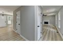 Bright hallway with modern flooring, white doors, and a glimpse into the inviting living room with fireplace at 545 Woodrow Dr, Lawrenceville, GA 30043