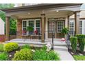 Welcoming front porch with stone accents, seating area and lush landscaping at 155 Edgewater Trl, Canton, GA 30115